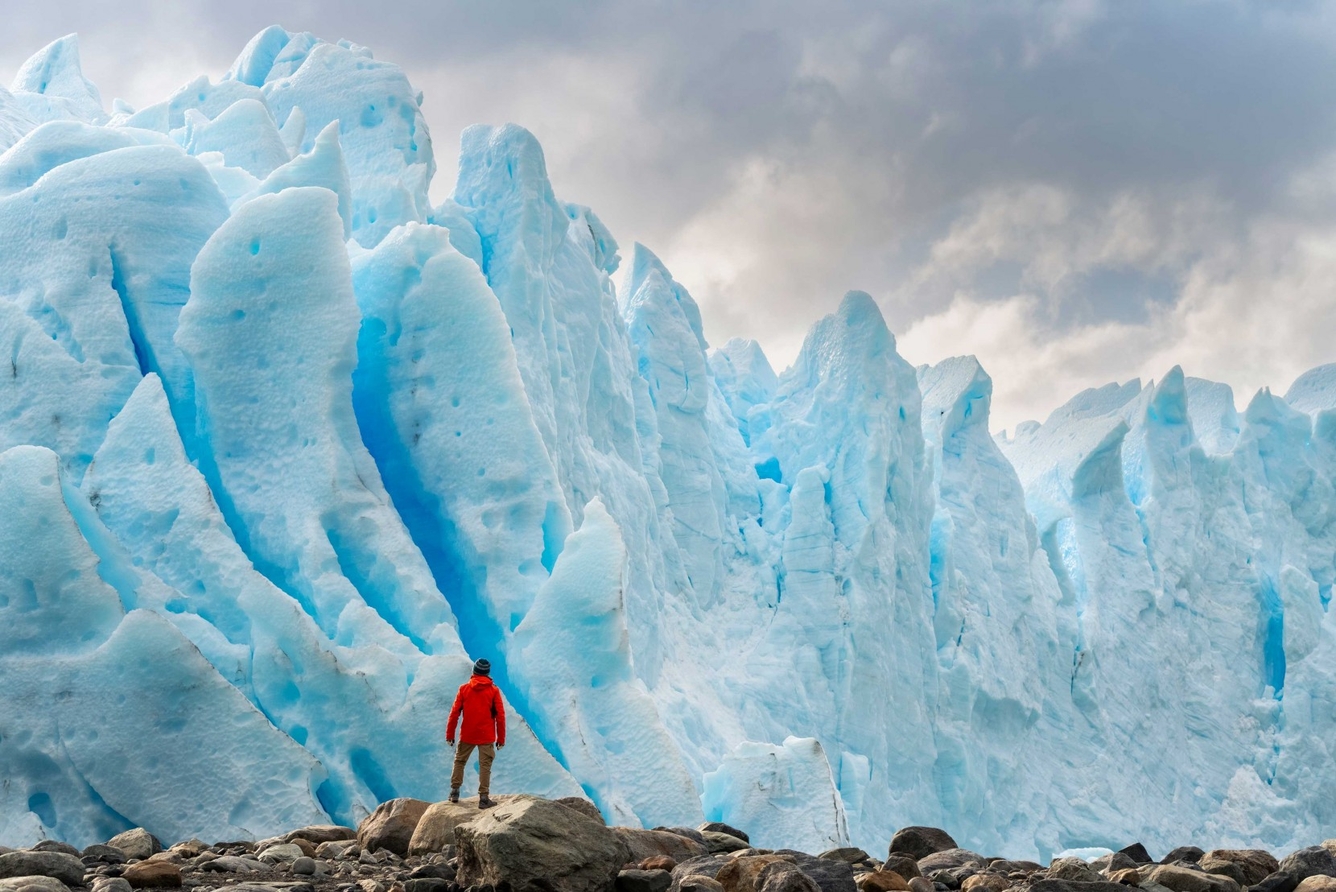 Man in front of ice cliff