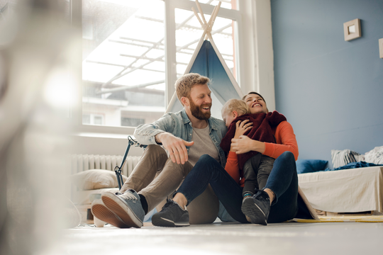 Happy family playing with their son at home