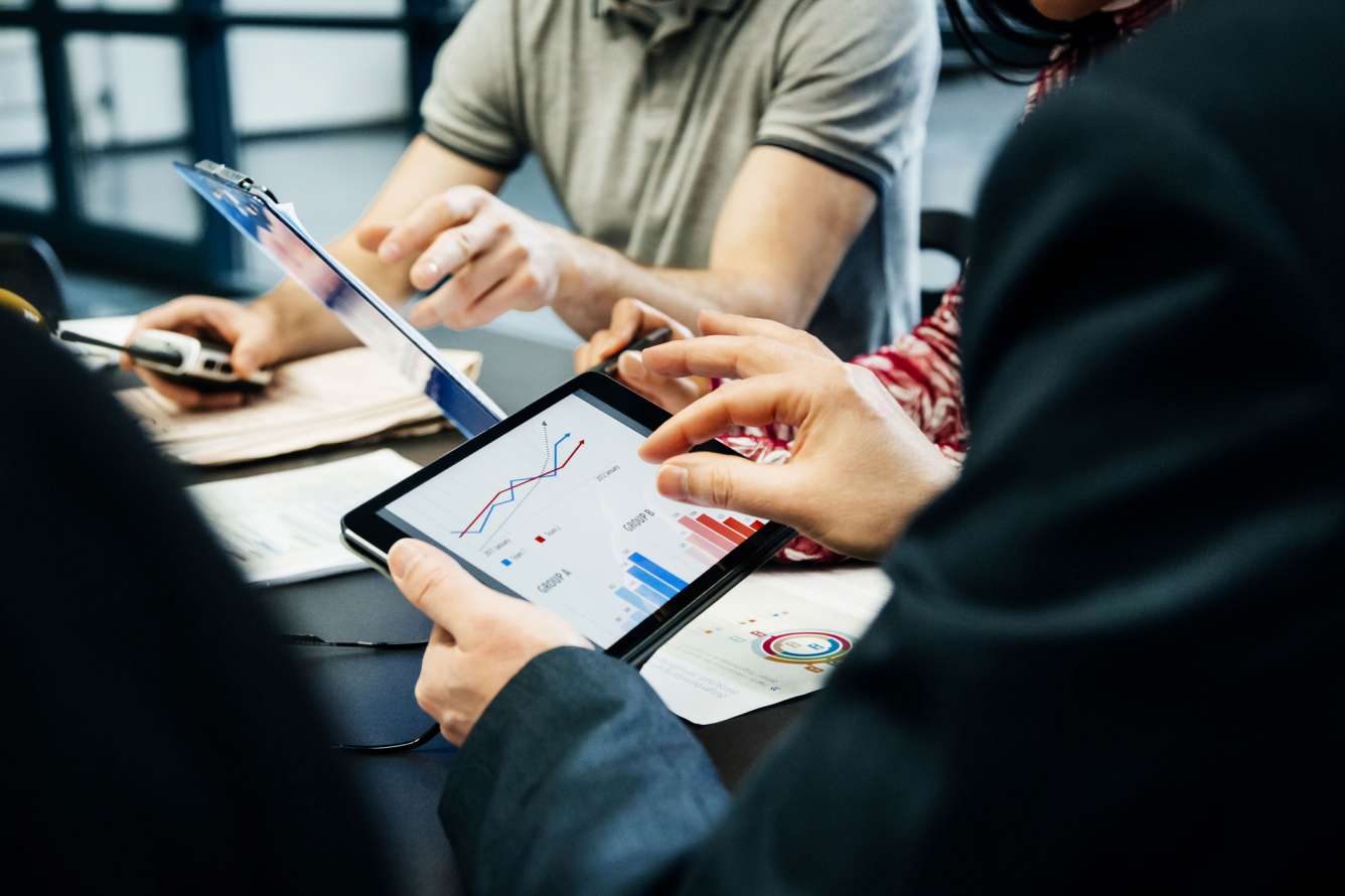 People holding tablets showing data and graphs