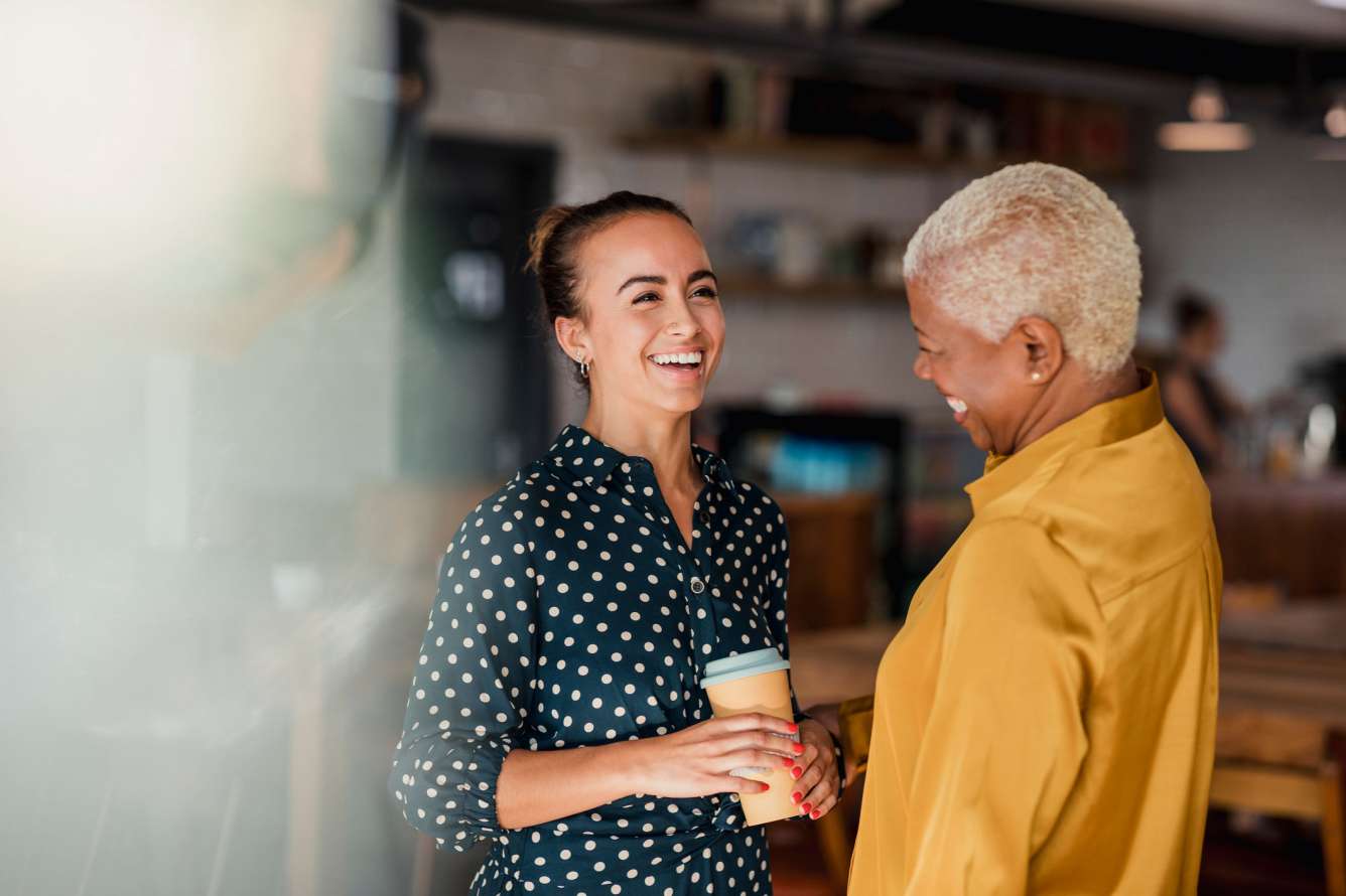 Two women chatting and enjoying a local coffee