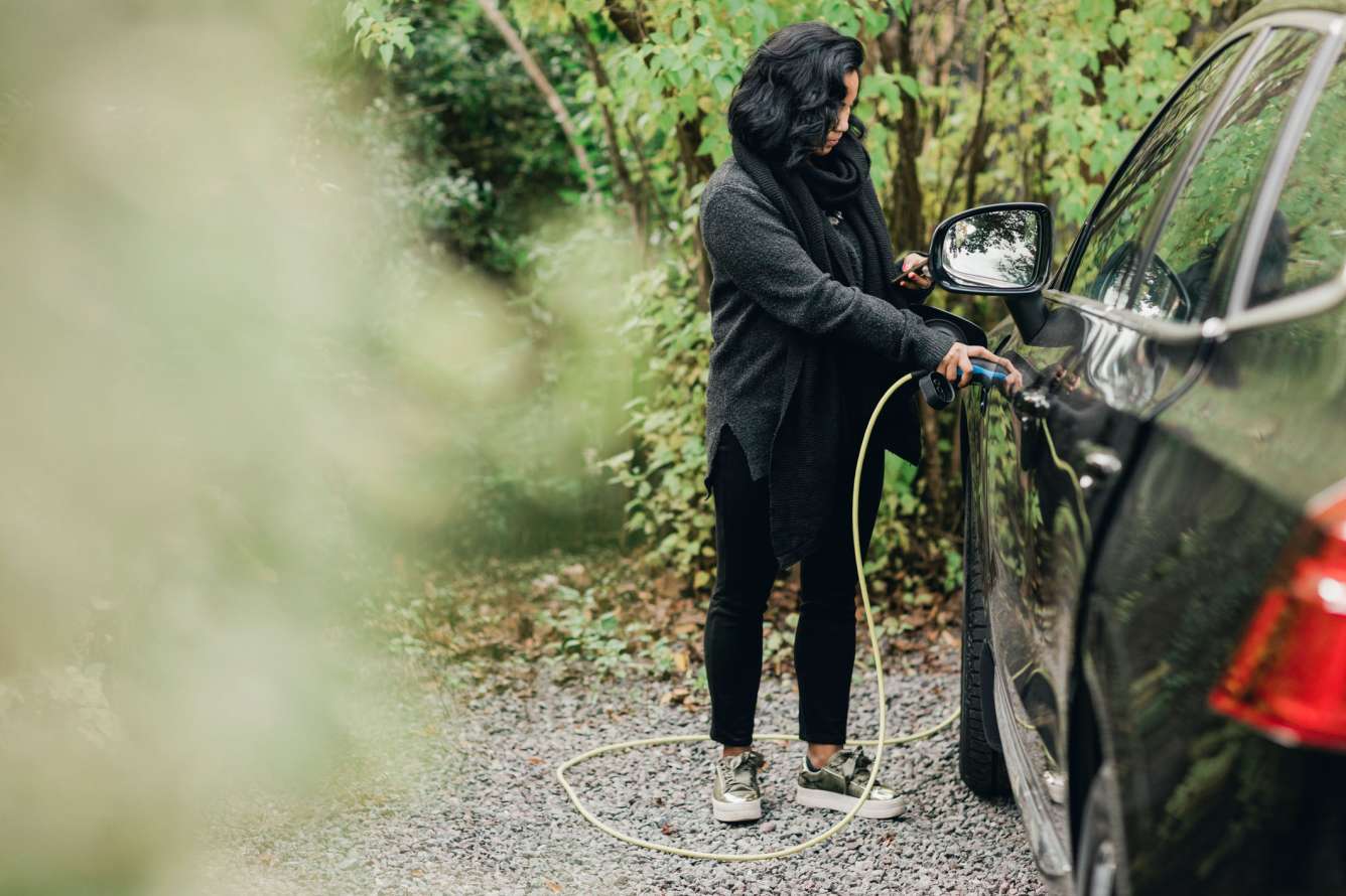 Woman charging electric car