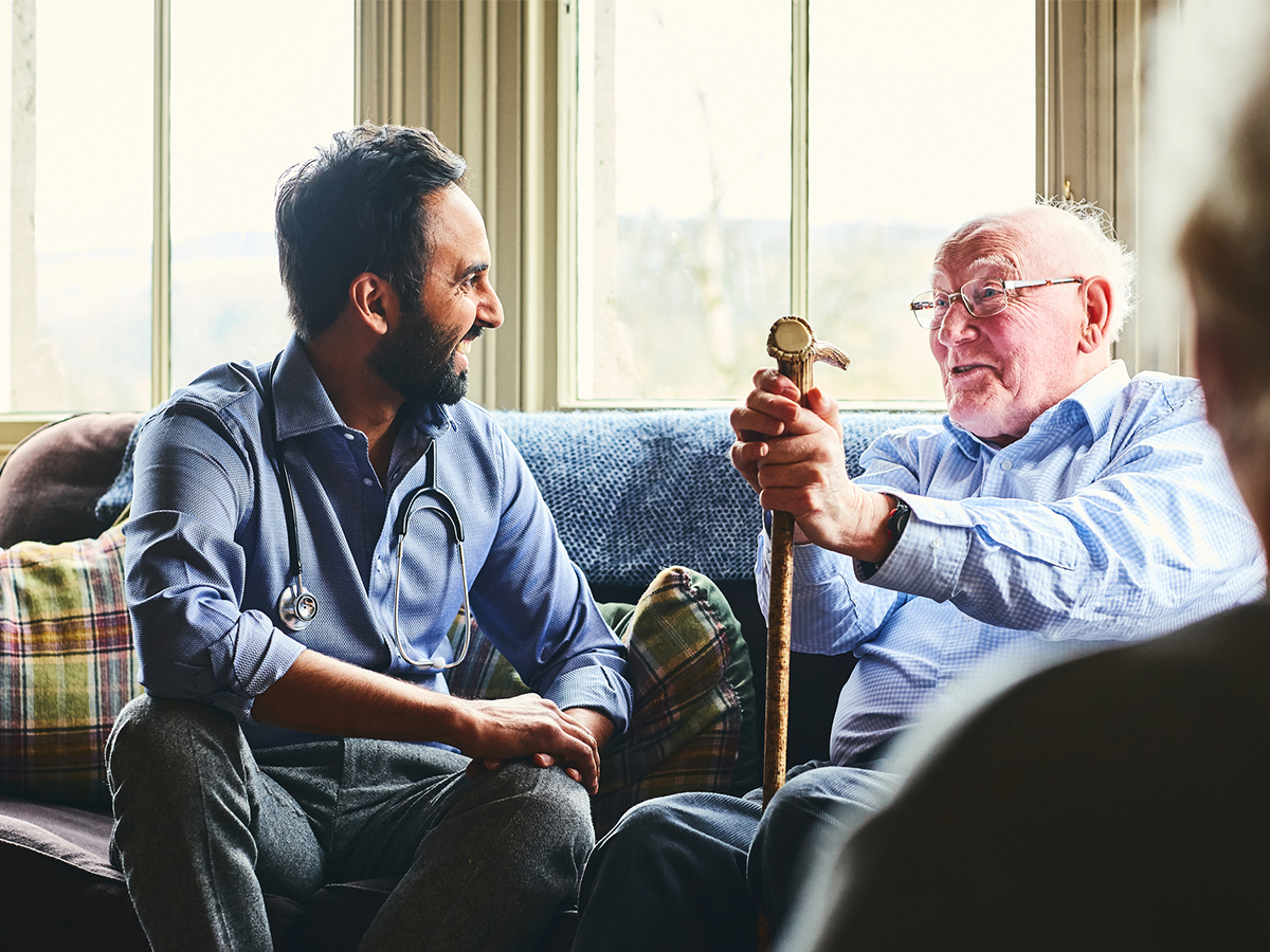 Doctor looking after elderly man at home