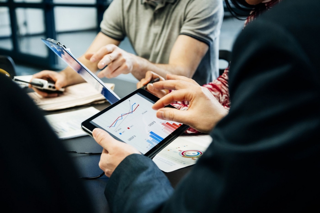 People holding tablets showing data and graphs