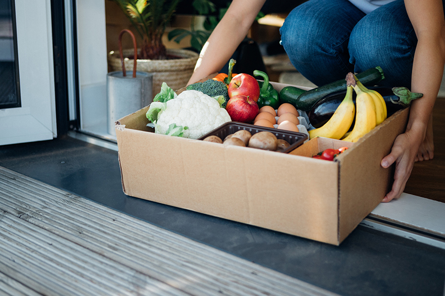 Young woman receiving fresh food home delivery