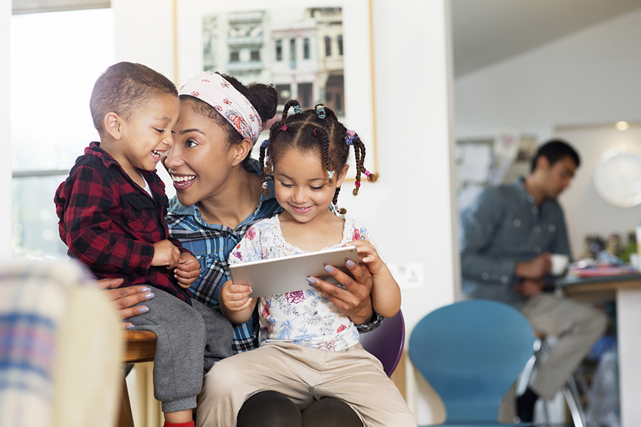 Mother, son and daughter having fun with tablet