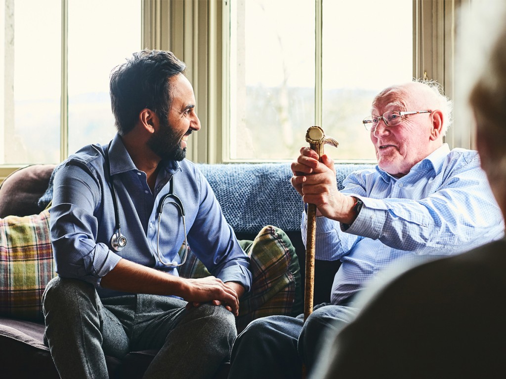 Doctor looking after elderly man at home